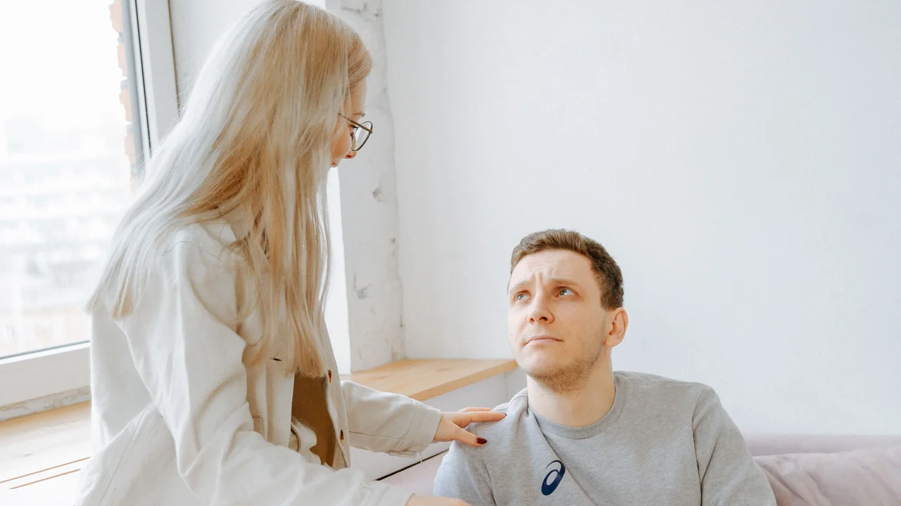 Two partners looking at each other during a serious but supportive conversation at home