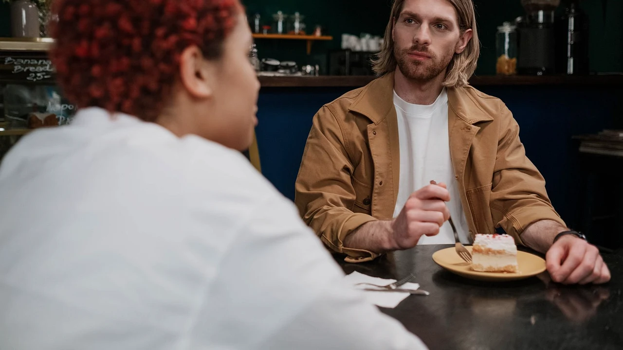 Two adults having a thoughtful first-date conversation at a cafe table