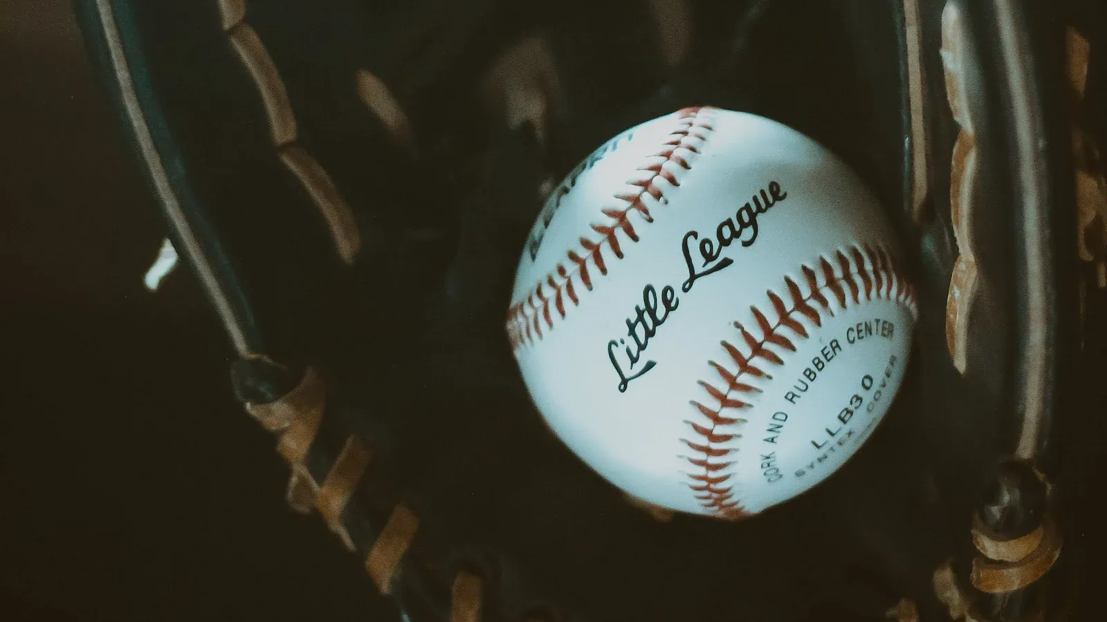 A worn leather baseball glove holding a baseball on the infield as the 2026 trade deadline approaches