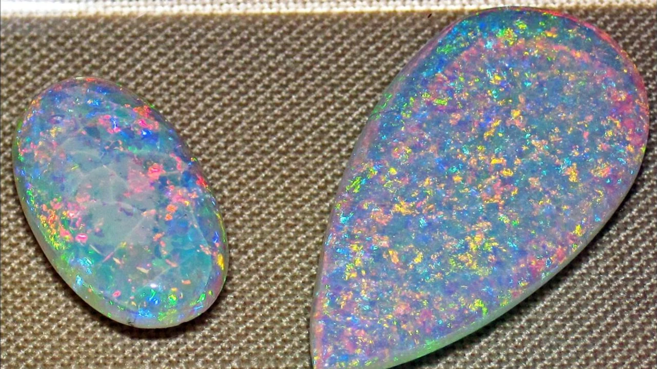 Two polished Australian precious opals flashing red, green, blue and yellow play-of-colour