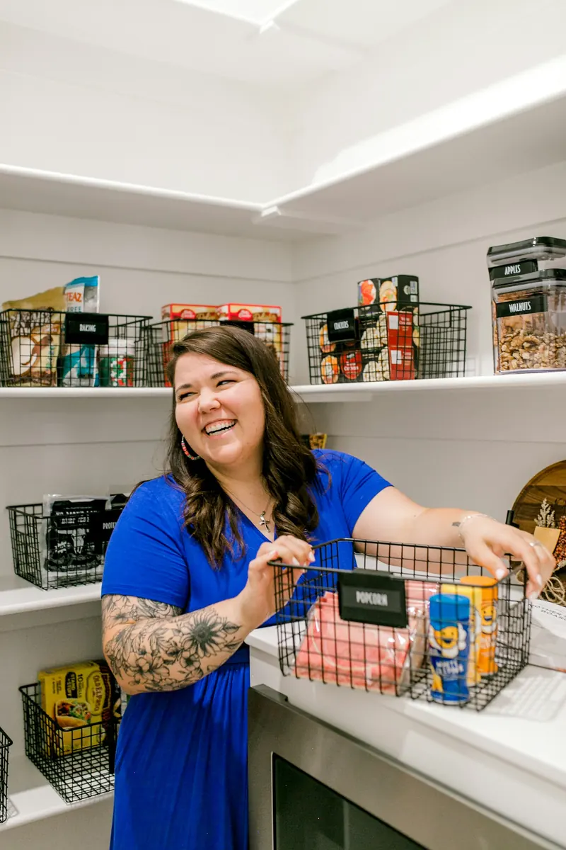 A person arranging labelled containers in an organised pantry