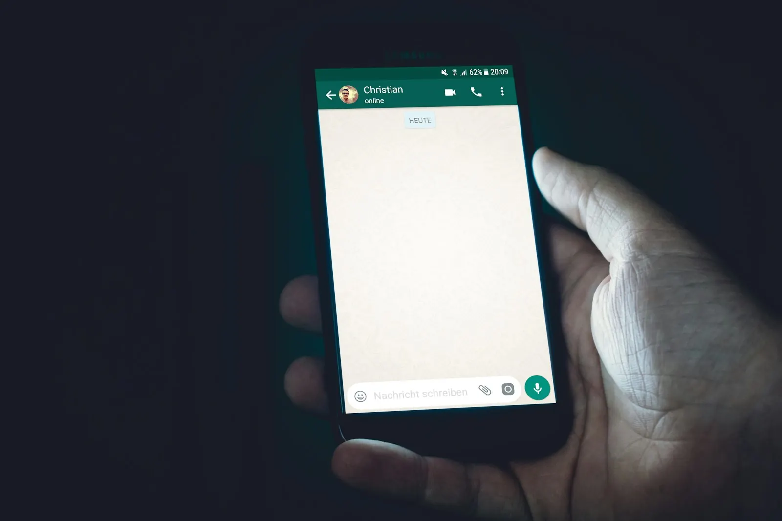 A person holding a smartphone with a messaging screen
