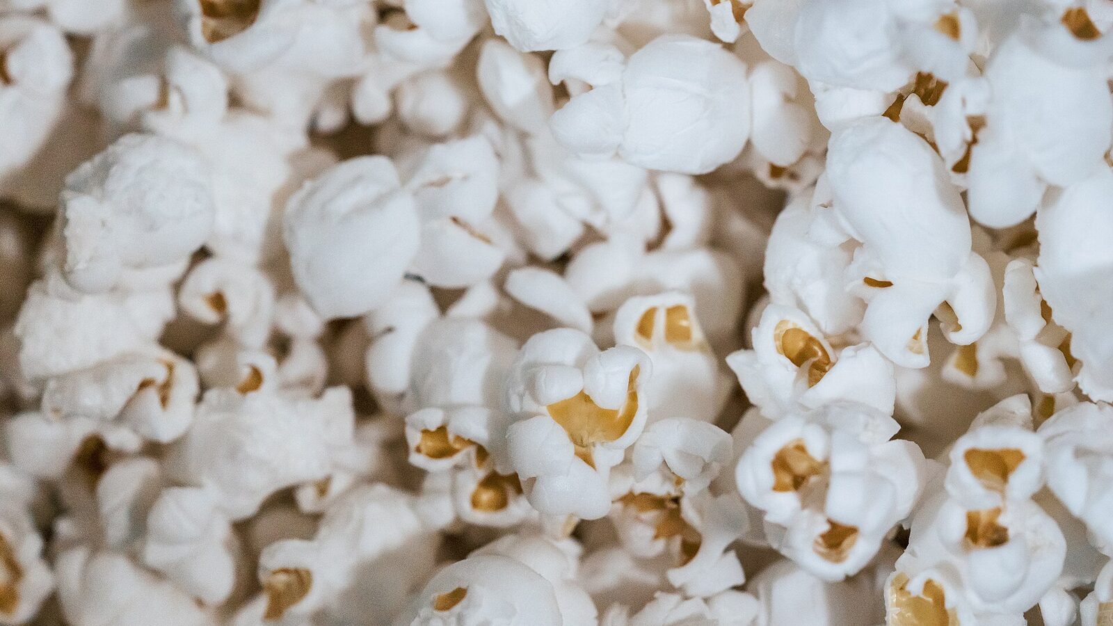 A close view of freshly air-popped white popcorn showing the folded shapes of the expanded starch