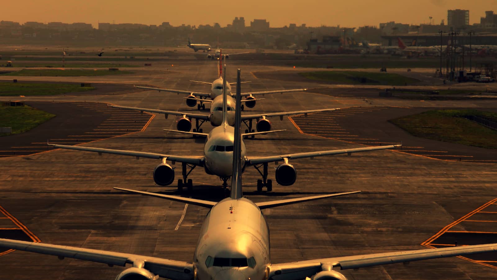 Four passenger aircraft lined up on a taxiway awaiting take-off at Mumbai airport