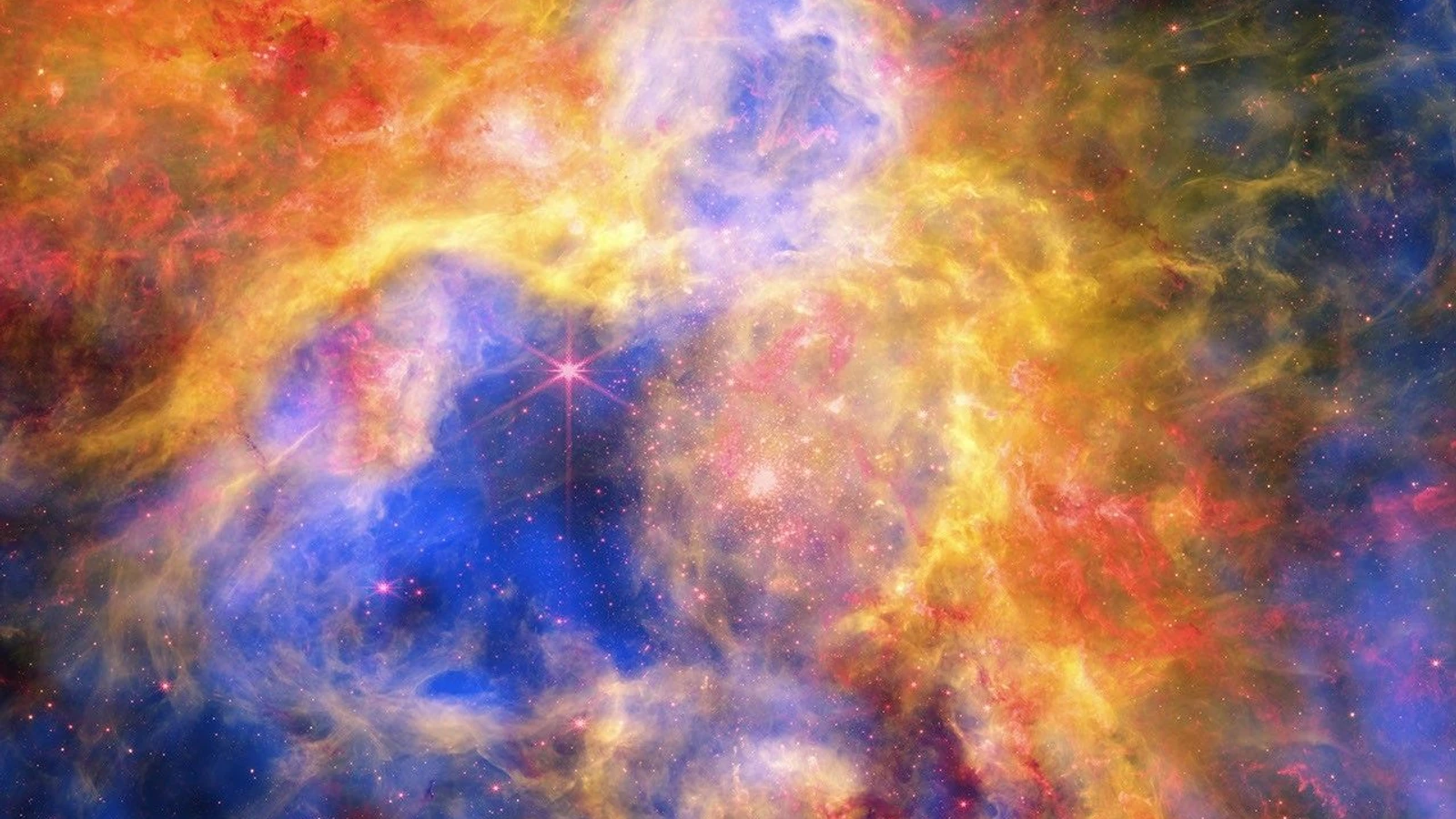 A NASA composite of 30 Doradus, the Tarantula Nebula, combines blue X-ray gas, red infrared dust and young stars, and green optical hydrogen and stars into one turbulent field