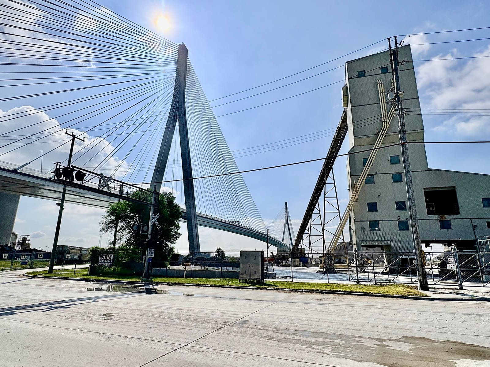 The completed Gordie Howe International Bridge rises above industrial buildings in Detroit, with its cable stays fanning from the nearest tower